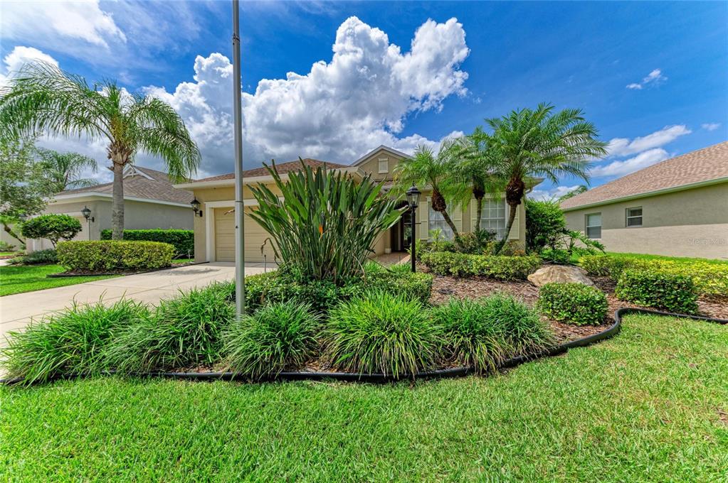 A single-story house with a tan exterior, a two-car garage, and landscaped front yard — 11763 FENNEMORE WAY, PARRISH, FL