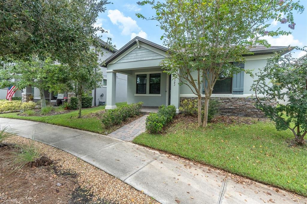 A single-story house with a stone facade, a covered front porch, and a paved walkway — 3343 HEART PINE AVENUE, ODESSA, FL