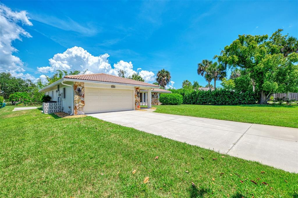 A single-story house with a beige garage, stone accents, and a concrete driveway — 2340 PALMETTO STREET, NOKOMIS, FL