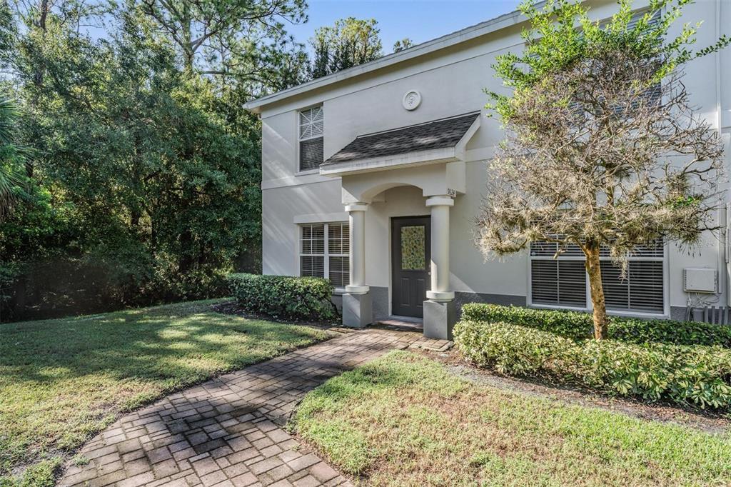 A two-story building exterior features a brick walkway leading to a covered front entrance — 9624 CHARLESBERG DRIVE, TAMPA, FL