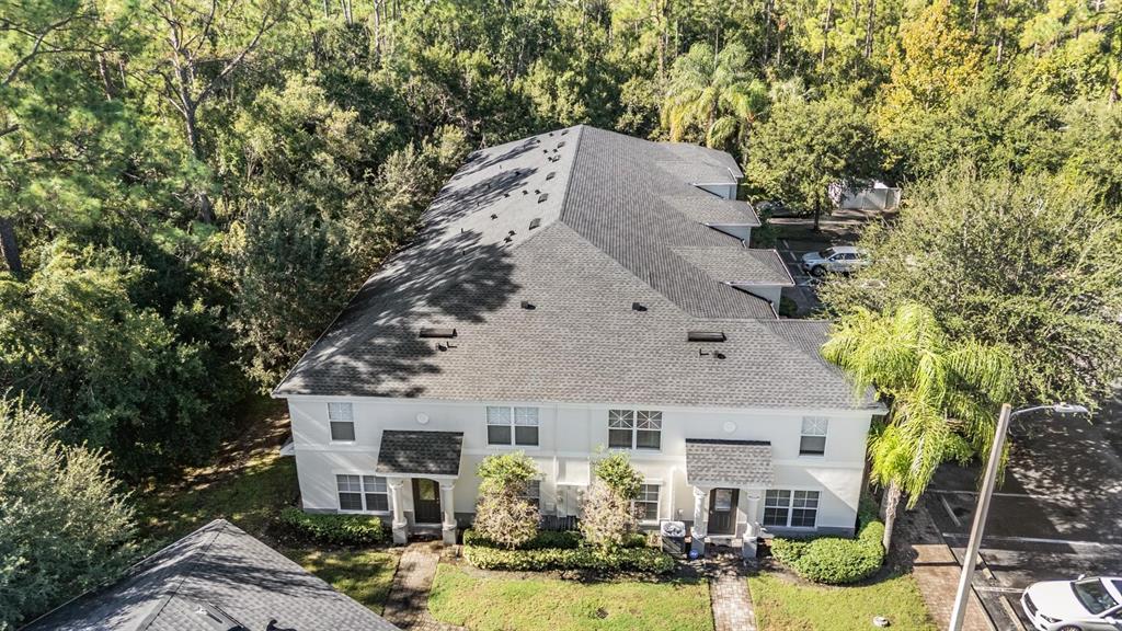 An aerial view of a two-story townhouse building with a gray shingled roof — 9624 CHARLESBERG DRIVE, TAMPA, FL