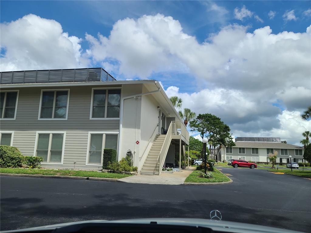 An exterior view of a two-story apartment building with beige siding and an outdoor staircase — 1935 CONWAY ROAD UNIT O5, ORLANDO, FL