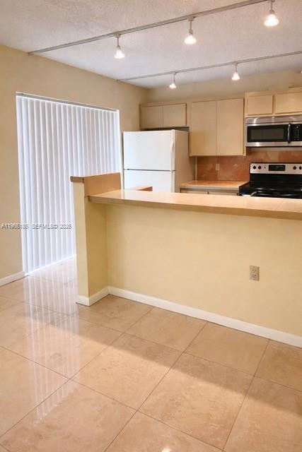 A kitchen with a breakfast bar, tile flooring, white appliances, and track lighting — 2610 26th way, Riviera Beach FL 33407, RIVIERA BEACH, FL