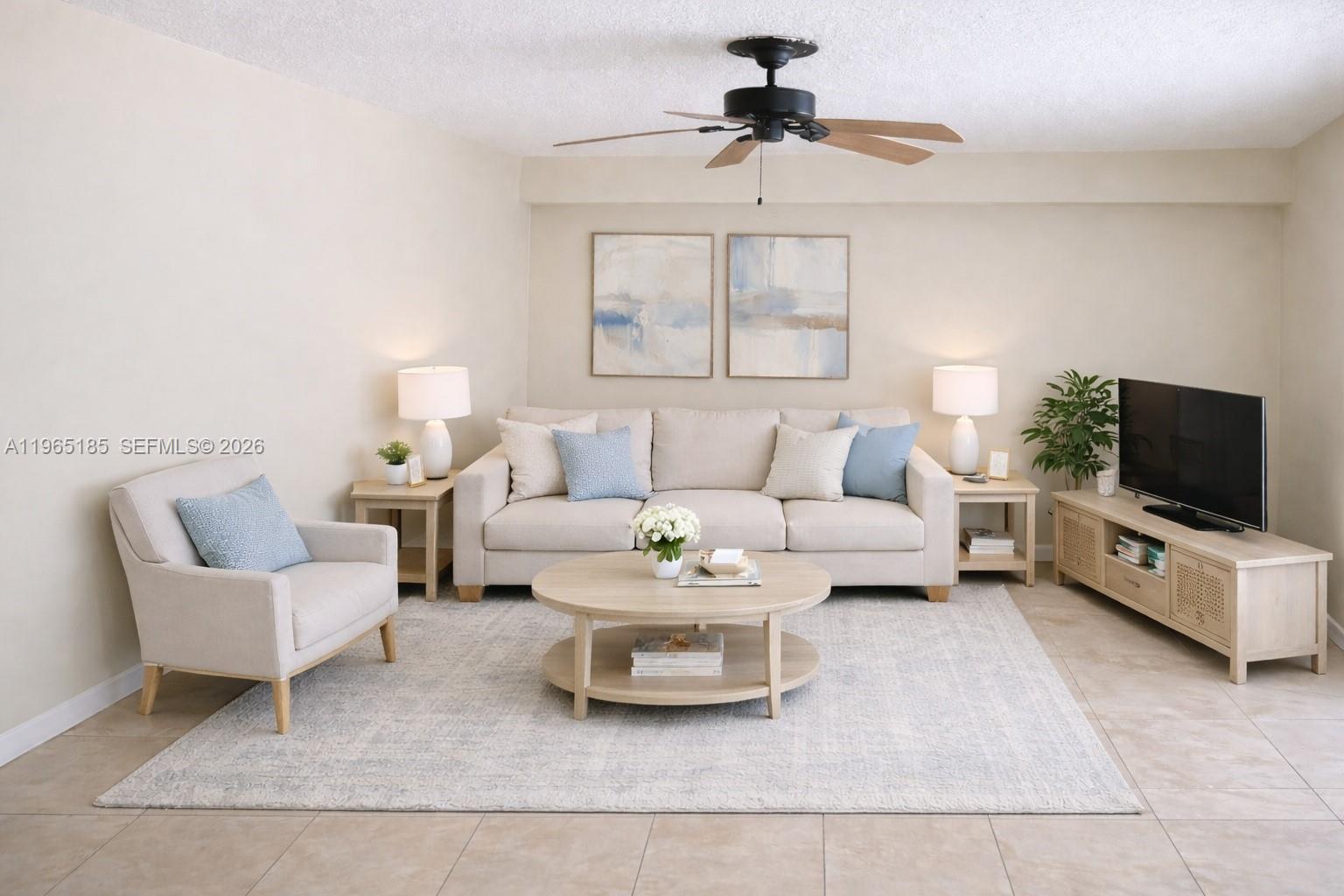 A beige living room features a sofa, armchair, coffee table, and television on a console — 2610 26th way, Riviera Beach FL 33407, RIVIERA BEACH, FL