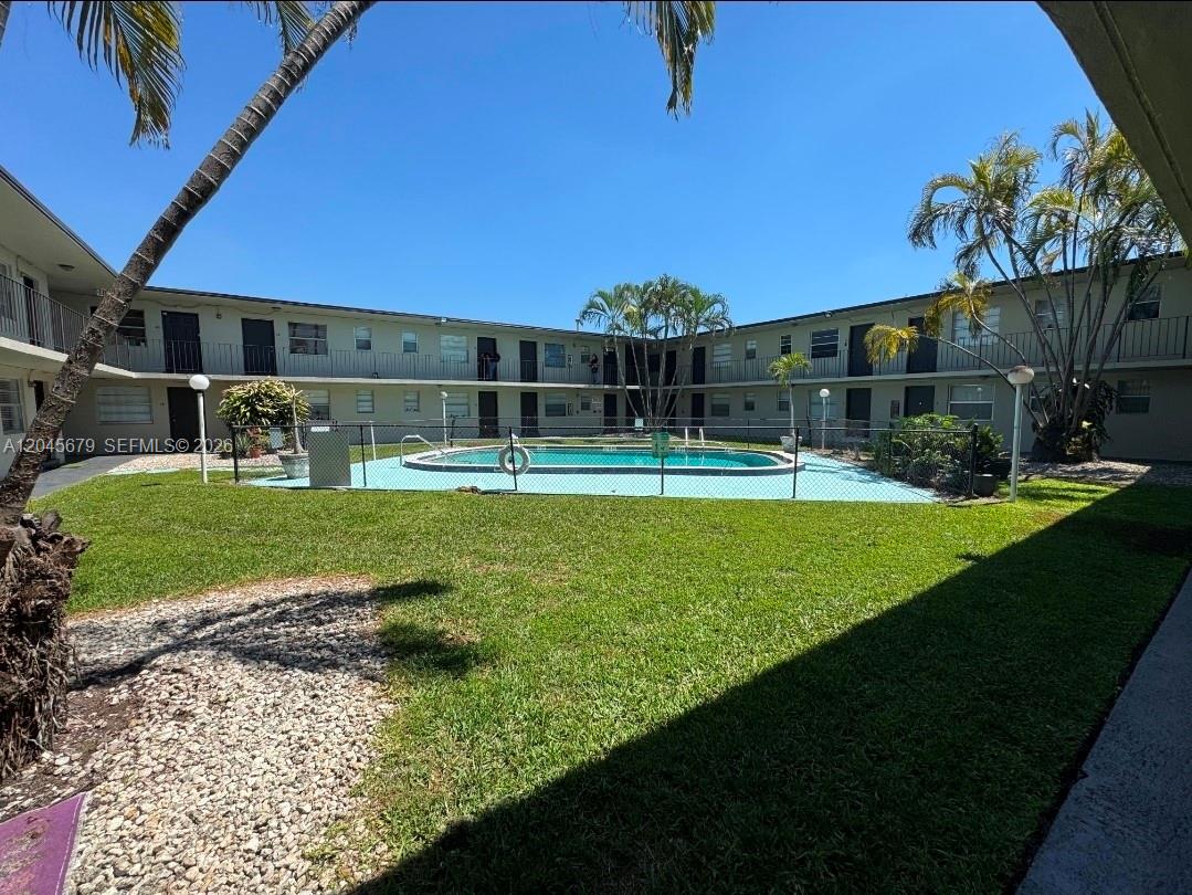 A fenced swimming pool sits in the courtyard of a two-story apartment complex — 3901 SW 112th Ave # 24, Miami FL 33165, MIAMI, FL