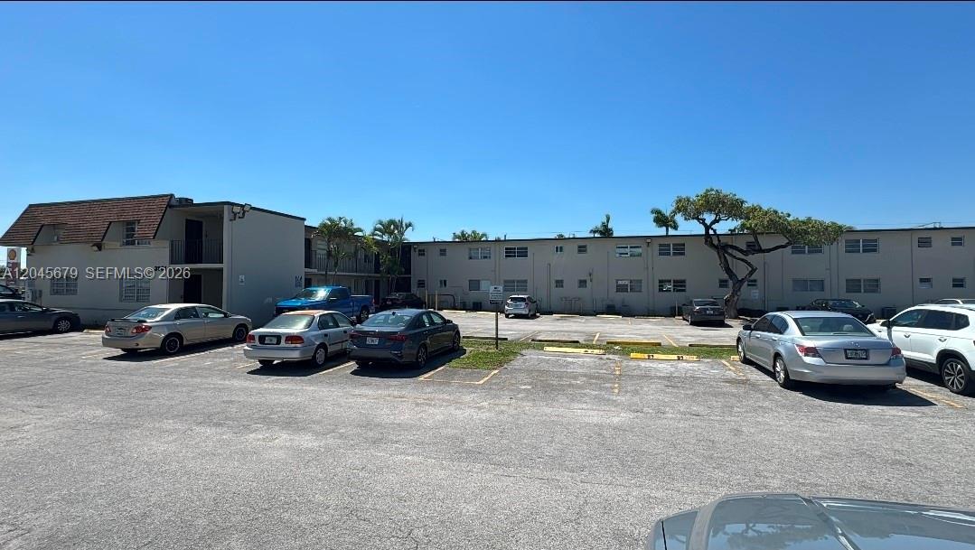 A multi-story apartment building exterior features a parking lot with several parked cars — 3901 SW 112th Ave # 24, Miami FL 33165, MIAMI, FL