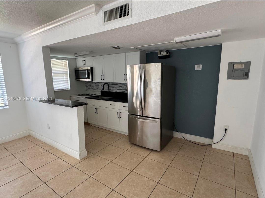 A kitchen features white cabinets, stainless steel appliances, and a dark countertop — 3901 SW 112th Ave # 24, Miami FL 33165, MIAMI, FL