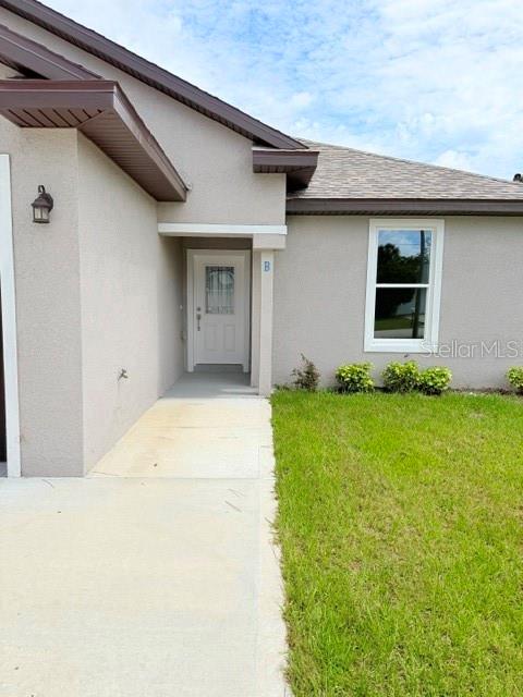 A beige house exterior features a front entrance with a white door and a window — 29 SLUMBER PATH UNIT B, PALM COAST, FL