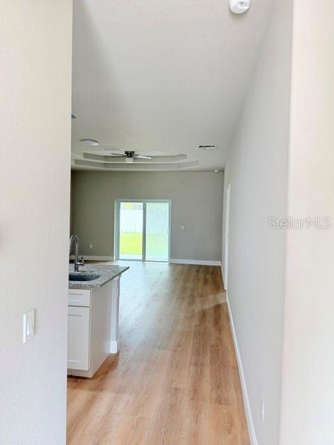 A view from a hallway looking into a kitchen and living area with wood flooring — 29 SLUMBER PATH UNIT B, PALM COAST, FL