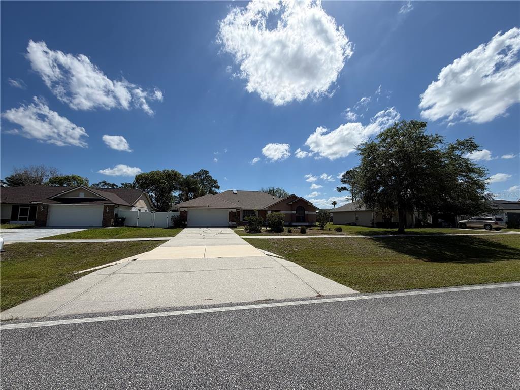 A single-story suburban house with a concrete driveway and a large tree in the yard — 2243 BANCROFT BOULEVARD, ORLANDO, FL