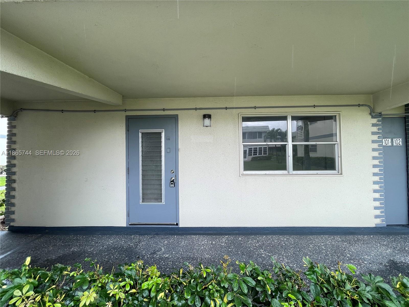 A gray door and a window are on the exterior wall of a building — 101 Brittany # C, Delray Beach FL 33446, DELRAY BEACH, FL
