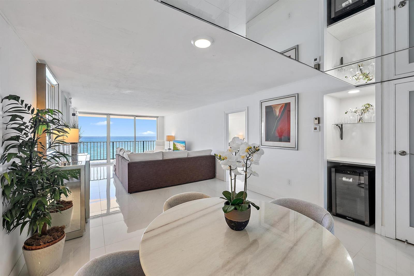 A bright living and dining area features white tile floors, a wet bar, and ocean views — 3456 S Ocean Boulevard # 802, Palm Beach FL 33480, PALM BEACH, FL