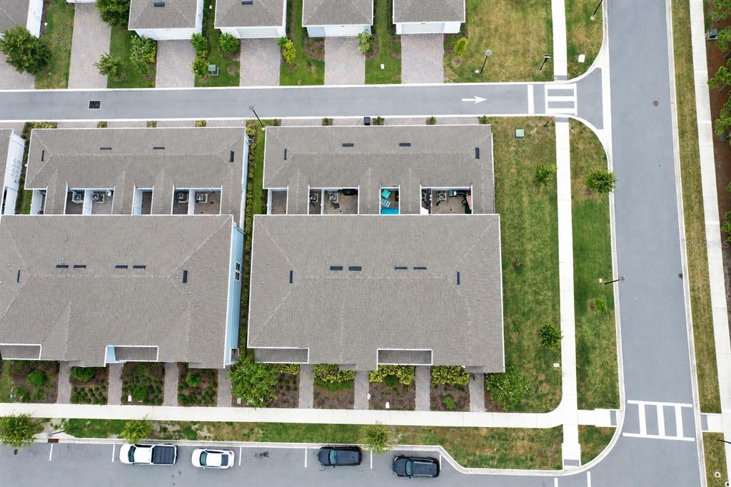 An aerial view shows a residential townhome complex with parking spaces and landscaped green areas — 14557 ORCHID ISLAND DRIVE, ORLANDO, FL