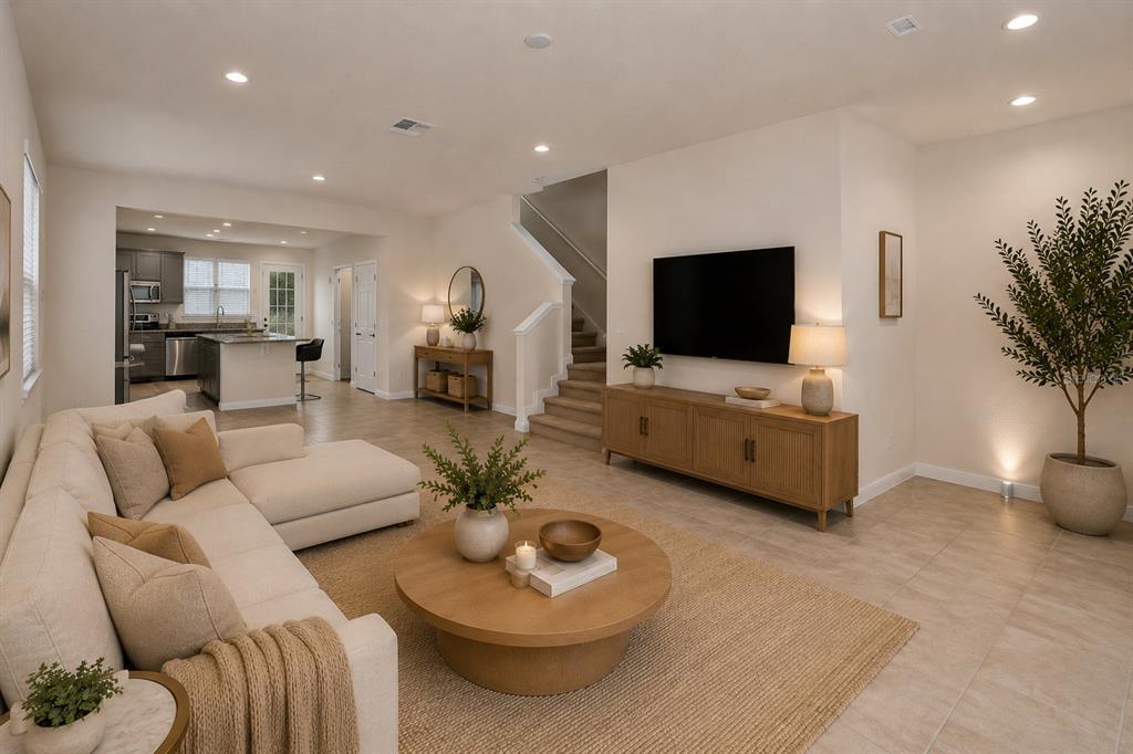 A living room features a sectional sofa, a round coffee table, and a wall-mounted television — 14557 ORCHID ISLAND DRIVE, ORLANDO, FL