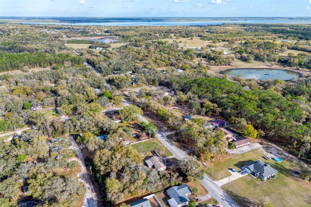 An aerial view shows a rural residential area with scattered houses, wooded lots, and ponds — LAKE GRIFFIN ROAD, LADY LAKE, FL