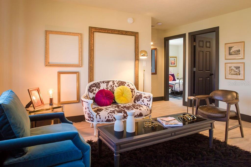 A living room features a cow-print settee, a blue armchair, and a dark coffee table — 6990 GREVILLA AVENUE S, SOUTH PASADENA, FL