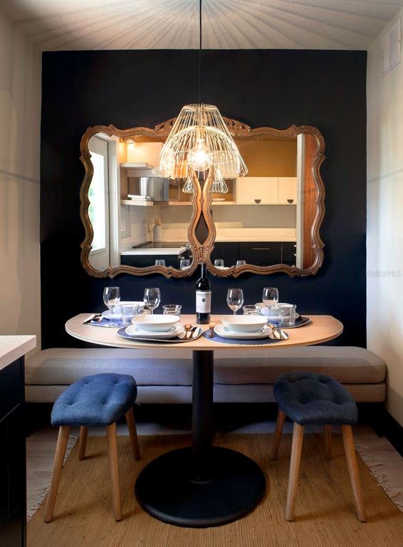 A dining nook features a semi-circular table, a bench, two stools, and a large ornate mirror — 6990 GREVILLA AVENUE S, SOUTH PASADENA, FL