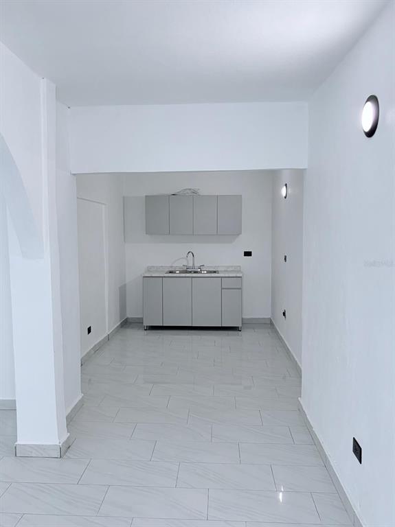 A small kitchen area features light gray cabinets, a stainless steel sink, and tiled flooring — 8 . UNIT 183, TOA ALTA, PR