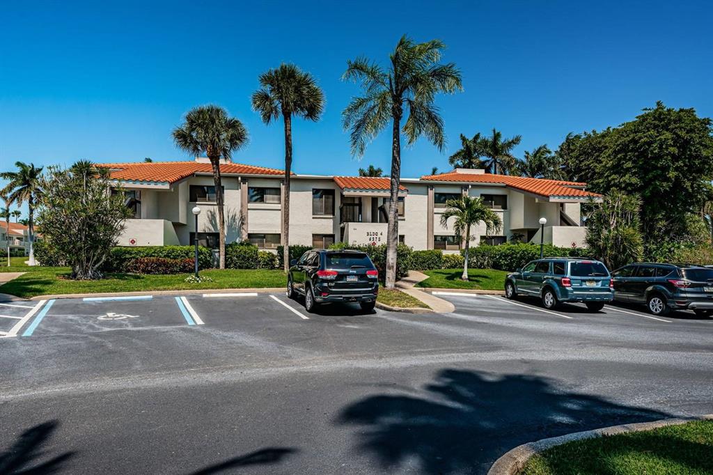 A two-story apartment building with a tiled roof and palm trees in the parking lot — 6273 BAHIA DEL MAR BOULEVARD UNIT 216, ST PETERSBURG, FL
