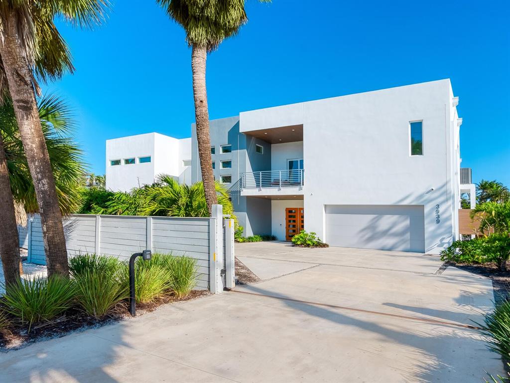 A modern two-story white house with a concrete driveway and a wooden front door — 3939 HIGEL AVENUE, SARASOTA, FL