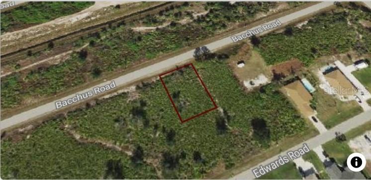 An aerial view shows a vacant rectangular plot of land outlined in red near roads — 12133 BACCHUS ROAD, PORT CHARLOTTE, FL