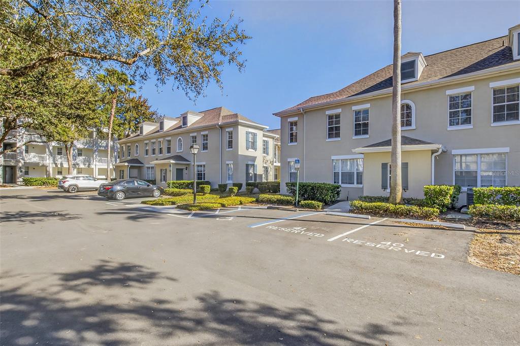 An exterior view of a multi-story apartment building with a paved parking lot in front — 760 SIENA PALM DRIVE UNIT 204, CELEBRATION, FL