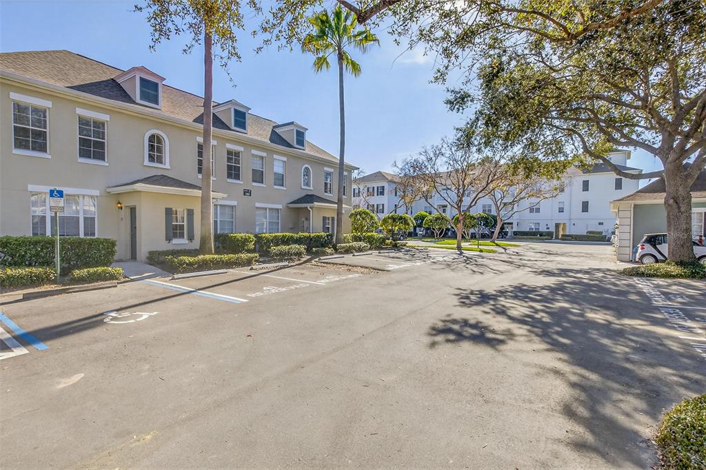 An exterior view of a multi-story apartment building with a parking lot in front — 760 SIENA PALM DRIVE UNIT 204, CELEBRATION, FL