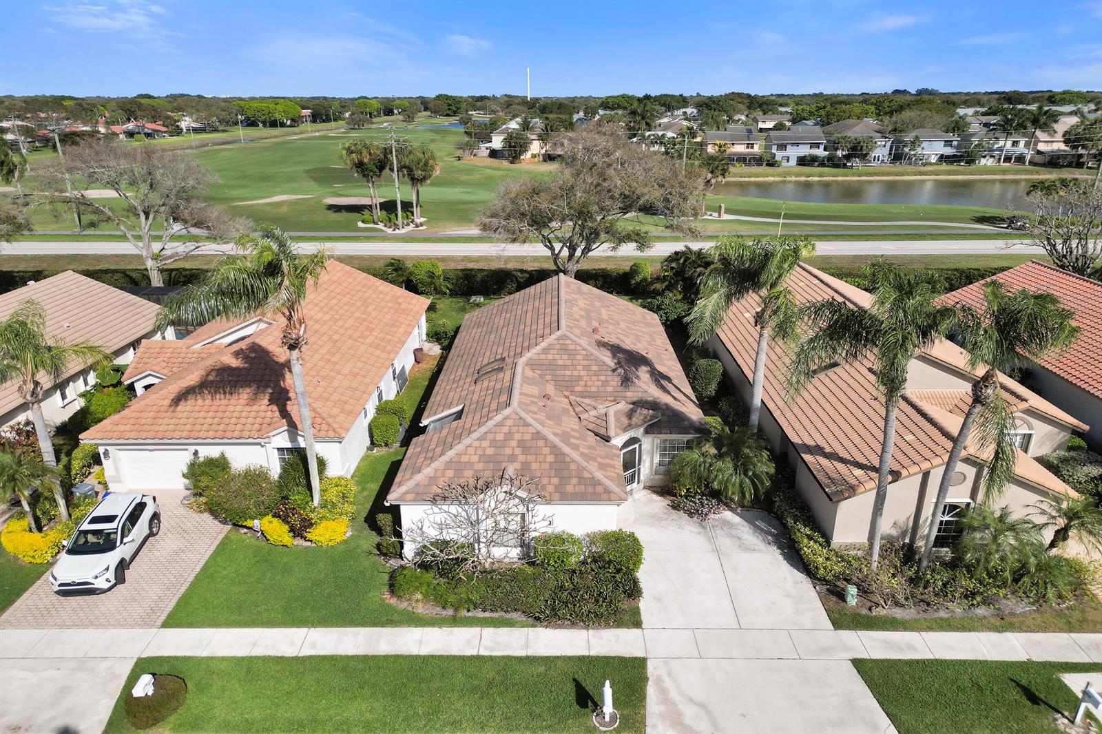 An aerial view shows three suburban houses with tiled roofs and palm trees near a golf course — 6115 Bay Isles Drive, Boynton Beach FL 33437, BOYNTON BEACH, FL