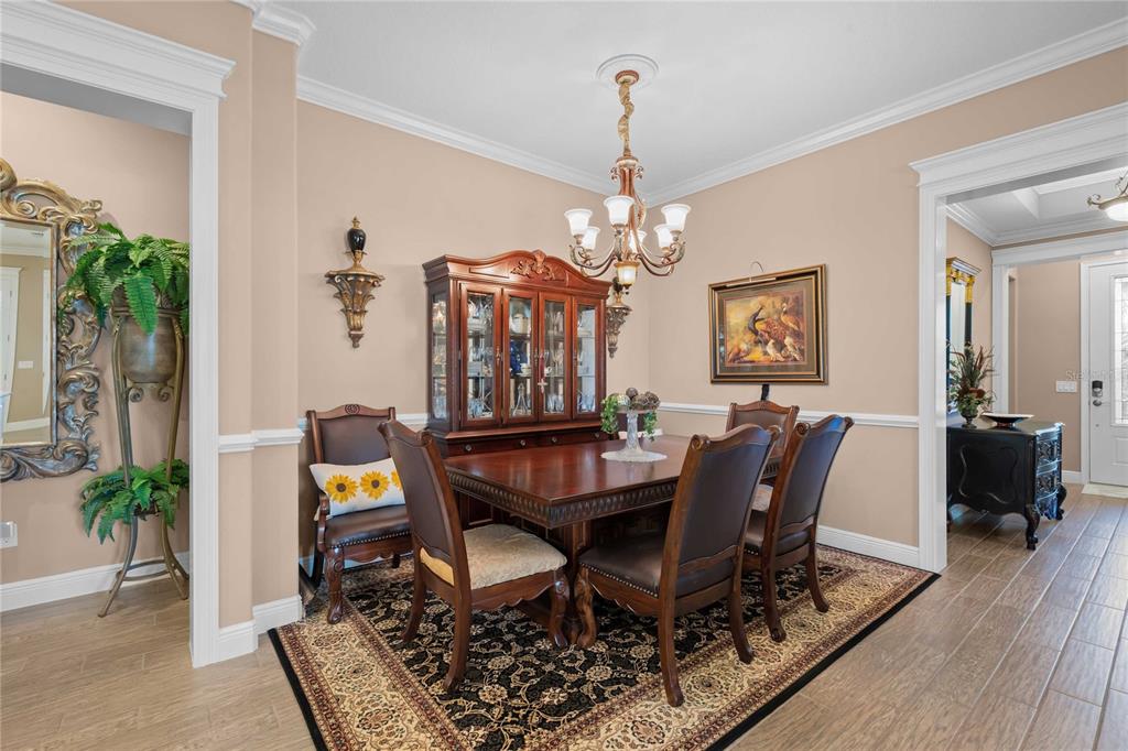 A formal dining room features a wooden table, chairs, a hutch, and a patterned rug — 3506 NW 55TH CIRCLE, OCALA, FL