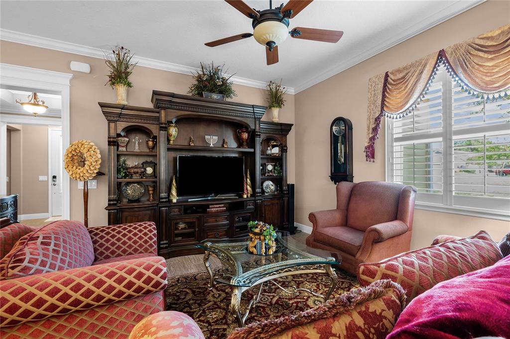A living room features a large wooden entertainment center, a patterned rug, and upholstered furniture — 3506 NW 55TH CIRCLE, OCALA, FL