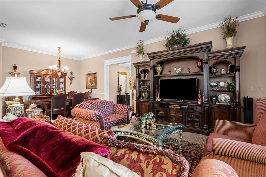 A living room features a large entertainment center, patterned furniture, and an adjacent dining area — 3506 NW 55TH CIRCLE, OCALA, FL