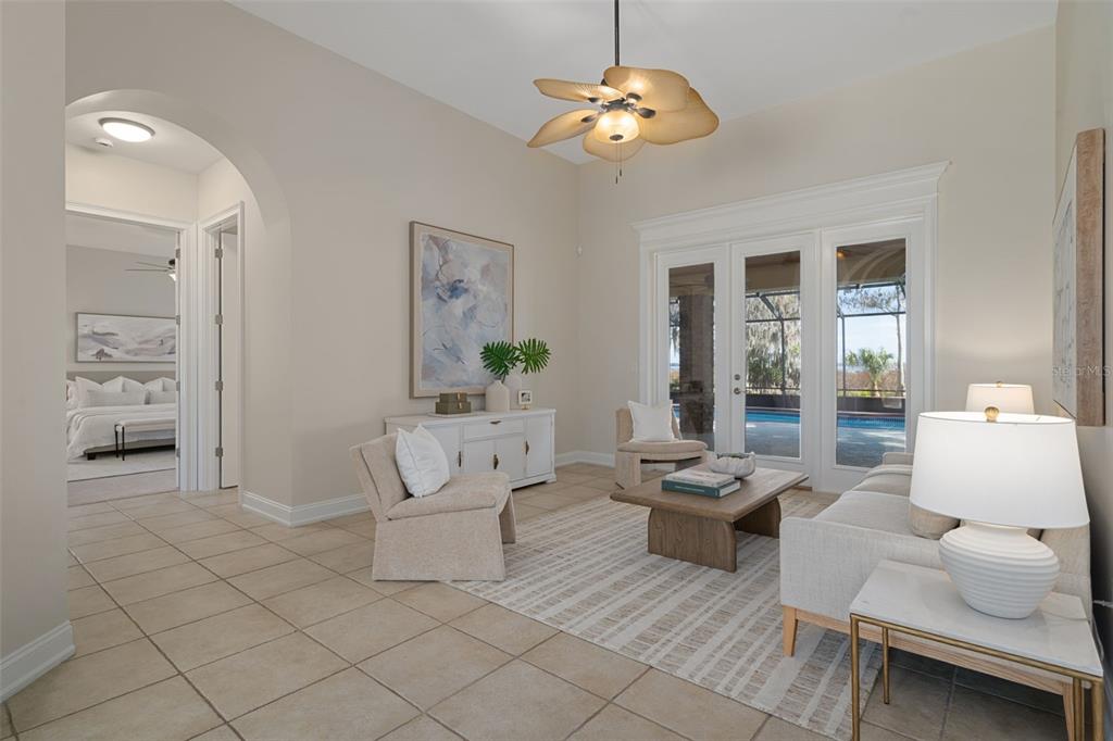 A living room features tile floors, a ceiling fan, and glass doors opening to a pool — 4300 TIMBERLANE ROAD, LAKE WALES, FL