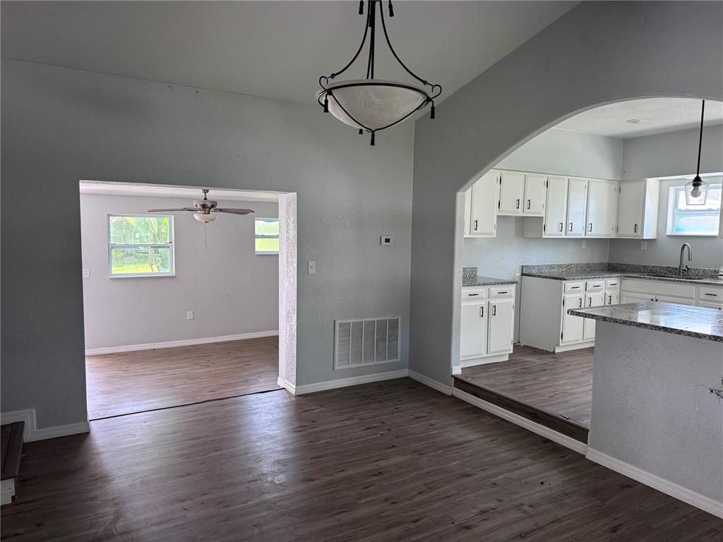 A dining area with a chandelier opens into a kitchen and a separate living space — 1142 SW MILDRED STREET, ARCADIA, FL