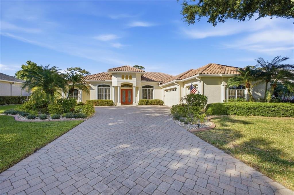 A single-story house with a tiled roof, arched entryway, and a paved driveway — 2309 LITTLE COUNTRY ROAD, PARRISH, FL