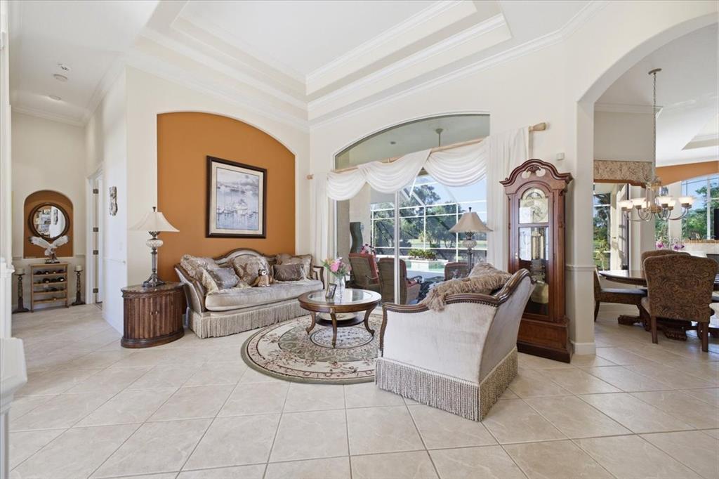 A living room with tile floors, a coffered ceiling, and an arched wall niche — 2309 LITTLE COUNTRY ROAD, PARRISH, FL