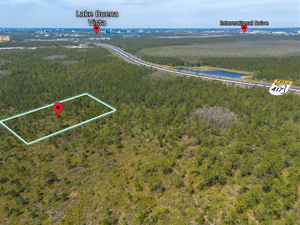 An aerial view shows a rectangular plot of land outlined in blue near a highway — SR-535, ORLANDO, FL