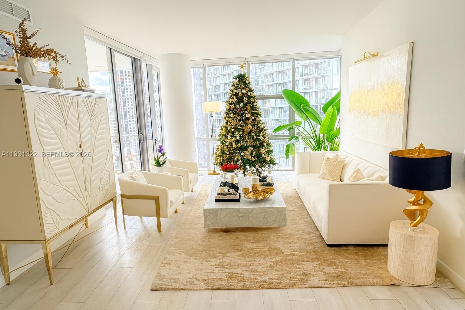 A bright living room features a white sofa, marble coffee table, and a Christmas tree — 851 NE 1st Ave # 2212, Miami FL 33132, MIAMI, FL