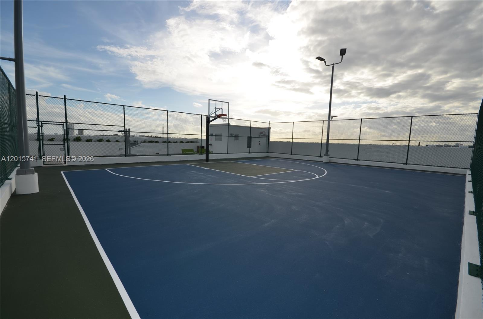An outdoor basketball court features a blue surface, a hoop, and a chain-link fence — 16385 Biscayne Blvd # 519, North Miami Beach FL 33160, NORTH MIAMI BEACH, FL