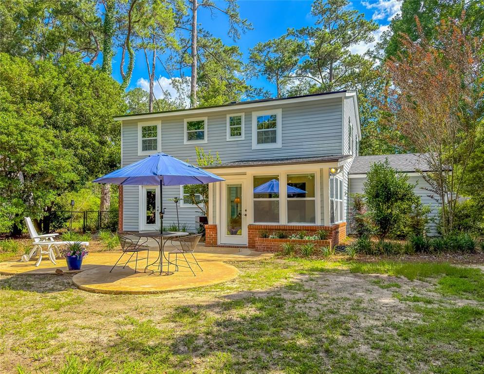A two-story house with gray siding features a patio, outdoor dining set, and umbrella — 2210 WALL STREET, TALLAHASSEE, FL
