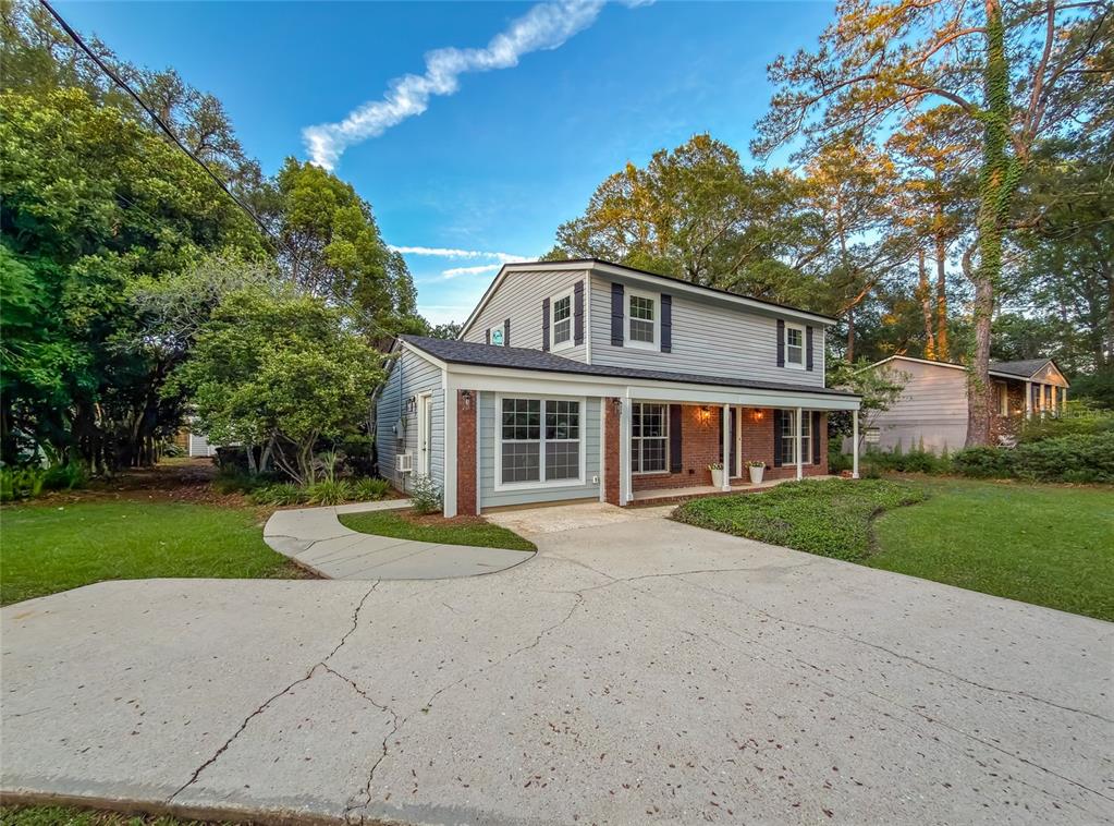 A two-story house with light blue siding, brick accents, and a concrete driveway — 2210 WALL STREET, TALLAHASSEE, FL
