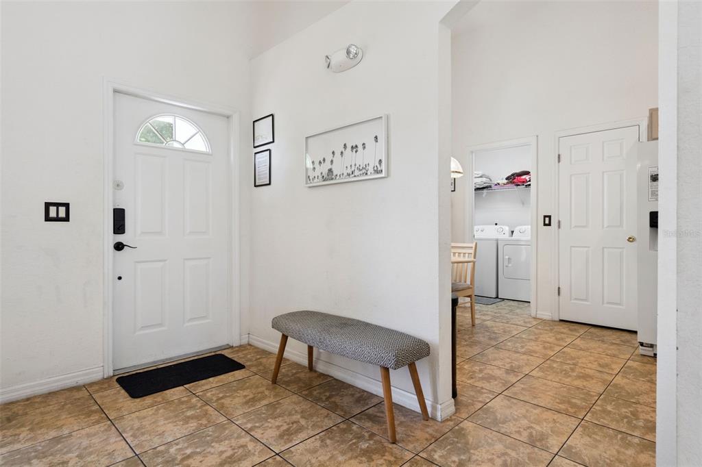 An entryway with tile flooring, a white front door, and a bench against the wall — 301 TROON CIRCLE, DAVENPORT, FL