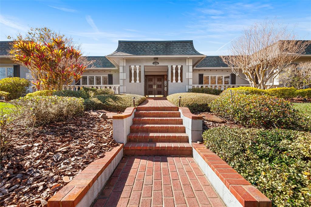 A brick walkway leads up steps to the front entrance of a single-story house — 1249 LAKE POINT DRIVE, LAKELAND, FL