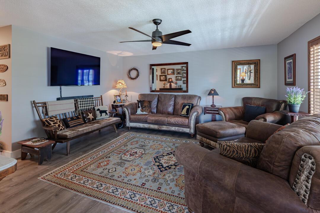 A living room features leather furniture, a patterned area rug, and a wall-mounted television — 2929 SE Ocean Boulevard # 10, Stuart FL 34996, STUART, FL