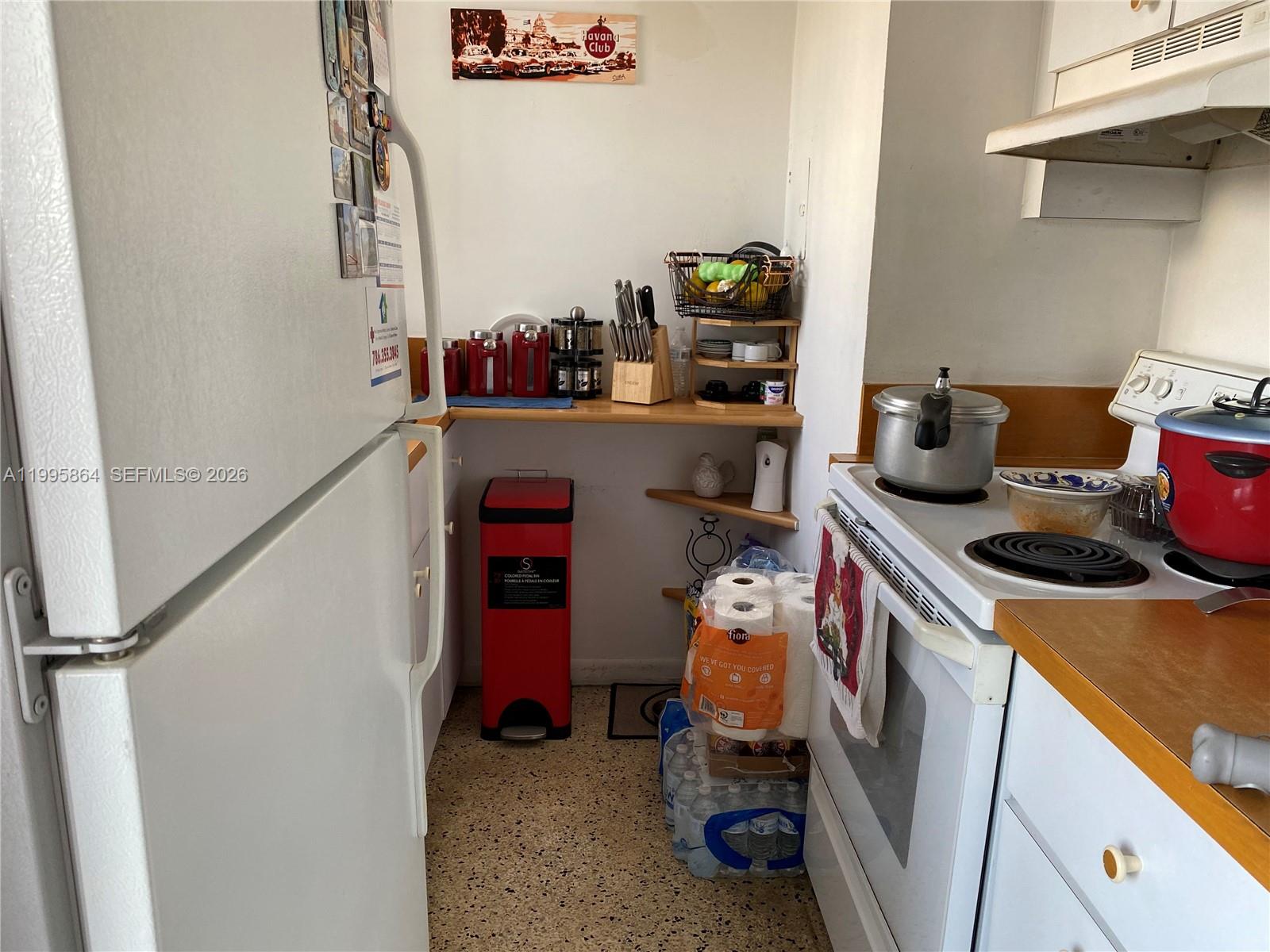 A small kitchen features white appliances, wooden countertops, and a red trash bin — 420 NW 12 Ave # 43, Miami FL 33128, MIAMI, FL