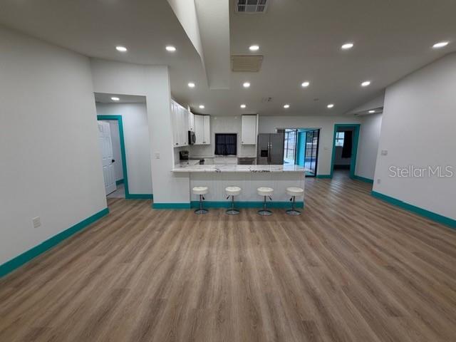 A bright room with light wood flooring, white walls, turquoise baseboards, and a turquoise door — 20167 HOLLAND AVENUE, PORT CHARLOTTE, FL