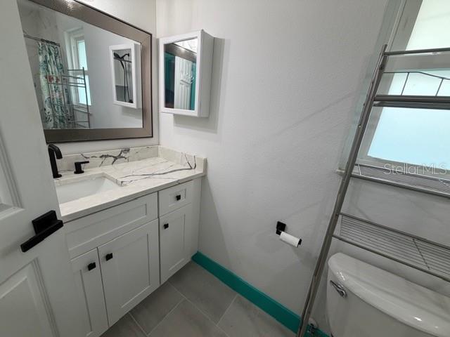 A kitchen with white cabinets, a marble-topped island, and turquoise trim overlooks a pool area — 20167 HOLLAND AVENUE, PORT CHARLOTTE, FL