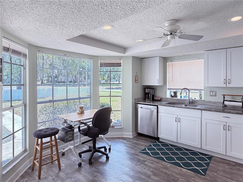 A kitchen features white cabinets, stainless steel appliances, and a small desk by the windows — 12901 CLUB DRIVE, HUDSON, FL