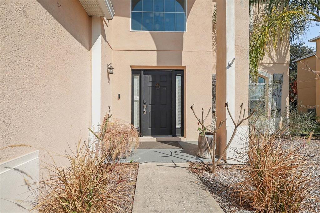 A two-story tan stucco house features a two-car garage and a concrete driveway — 548 BIG SIOUX COURT, KISSIMMEE, FL