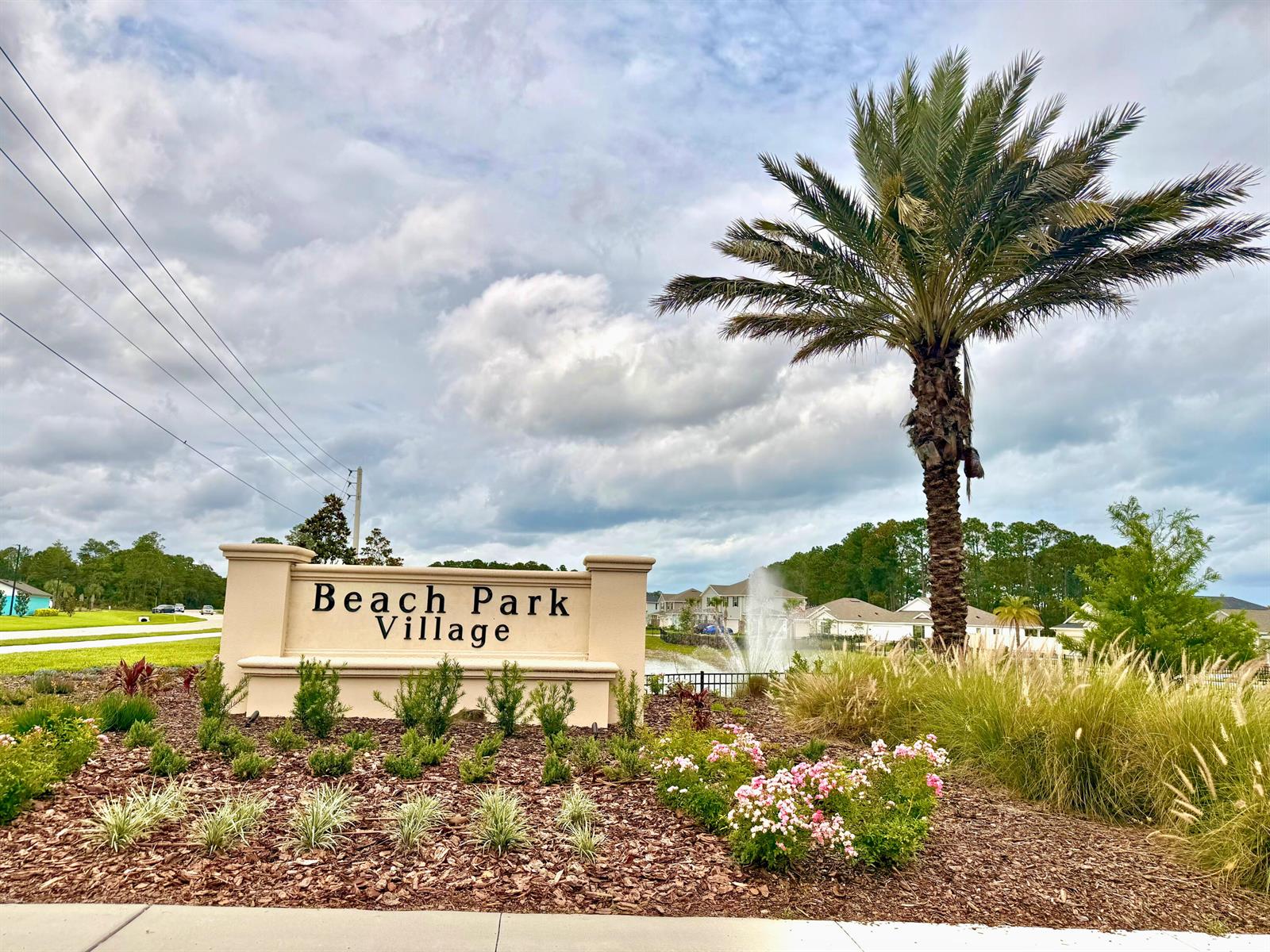 A beige monument sign for Beach Park Village stands near a palm tree and fountain — 65 Signet Circle, FL 32136, FL