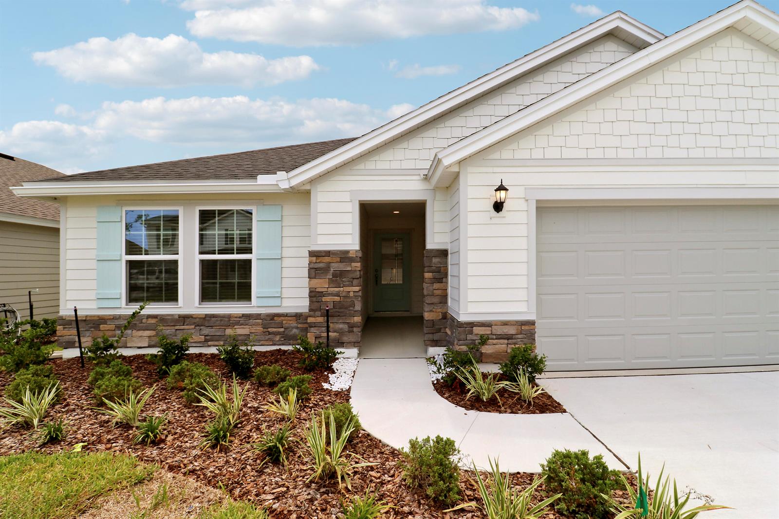 A single-story house exterior features white siding, stone accents, light blue shutters, and a garage — 65 Signet Circle, FL 32136, FL